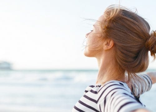 Happy woman at the beach after Kybella treatments